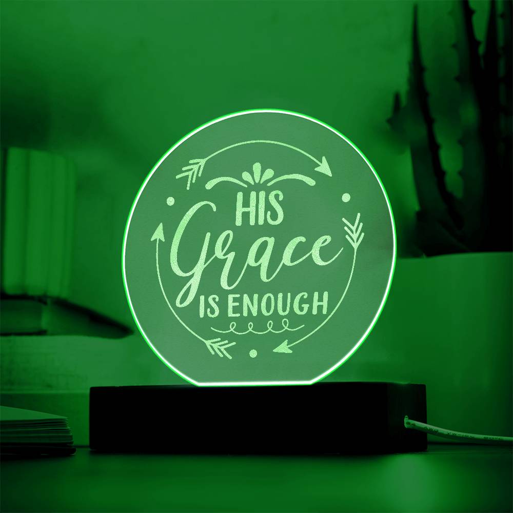 Round clear acrylic plaque with 'His Grace Is Enough' engraved on it. Illuminated with green LED light