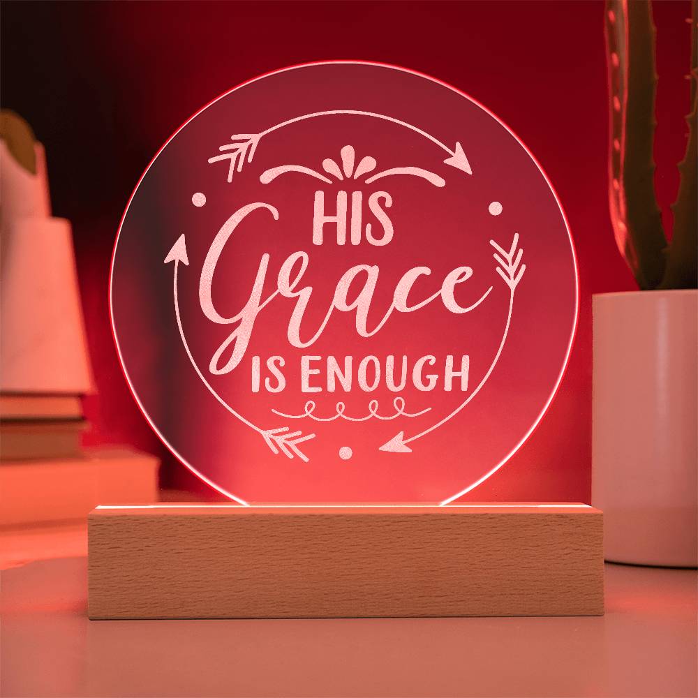 Round clear acrylic plaque with 'His Grace Is Enough' engraved on it. Illuminated with red LED light